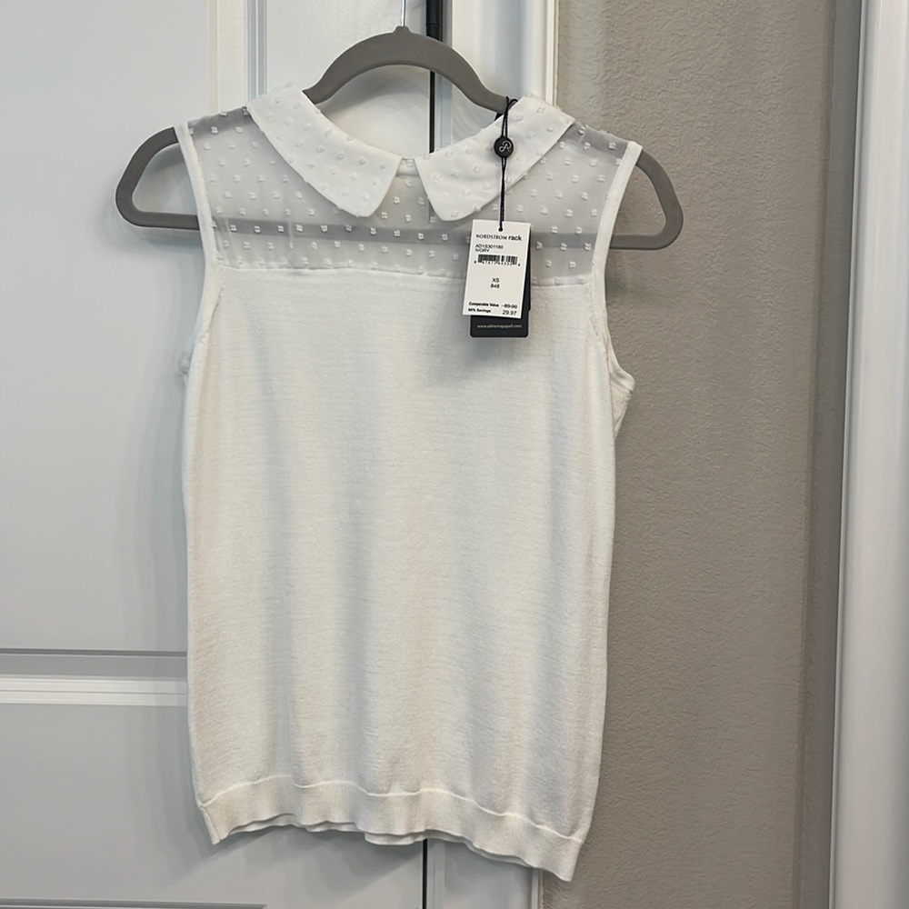 Lightweight sleeveless knit top with sheer accents around the collar.